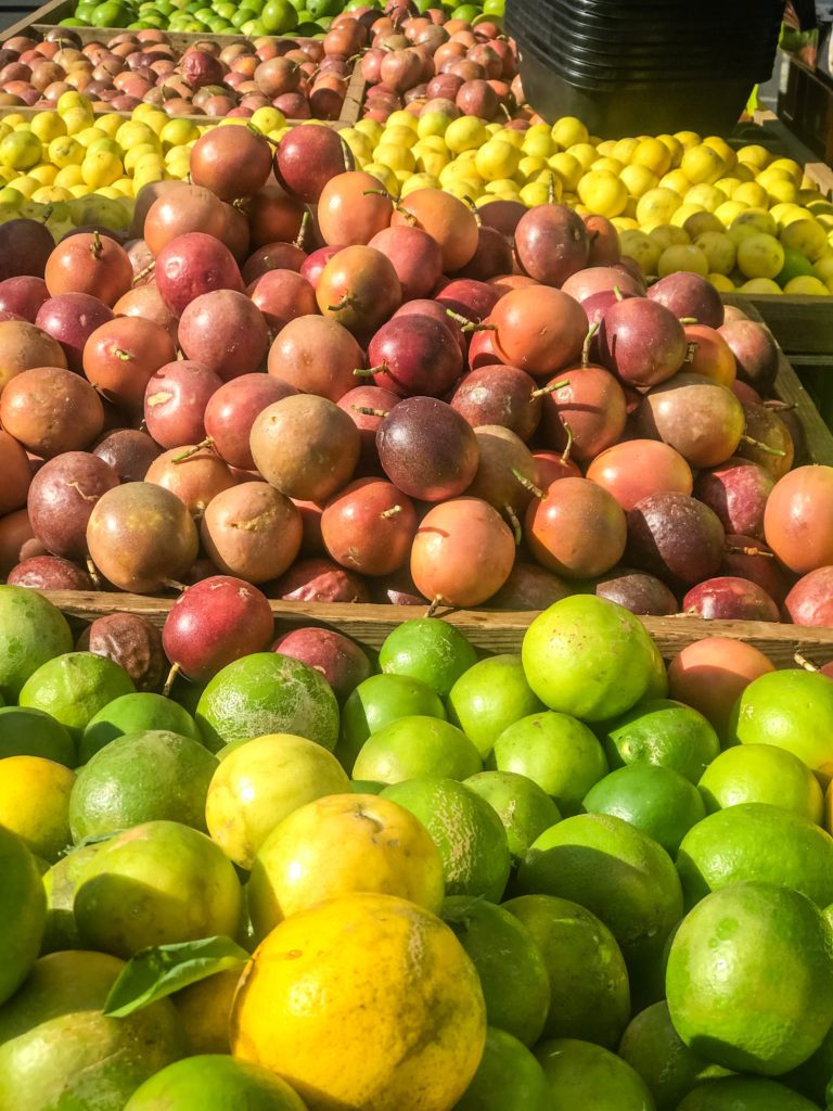 Étals de fruits de la passion, citrons verts et agrumes sur le marché forain